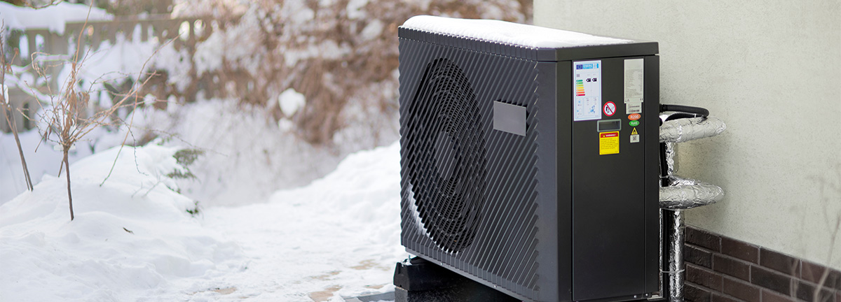 The outdoor unit of a heat pump with snow.